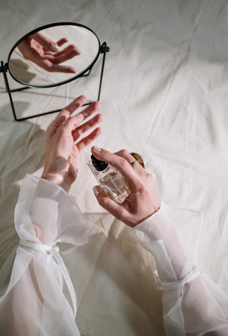 person holding clear glass bottle